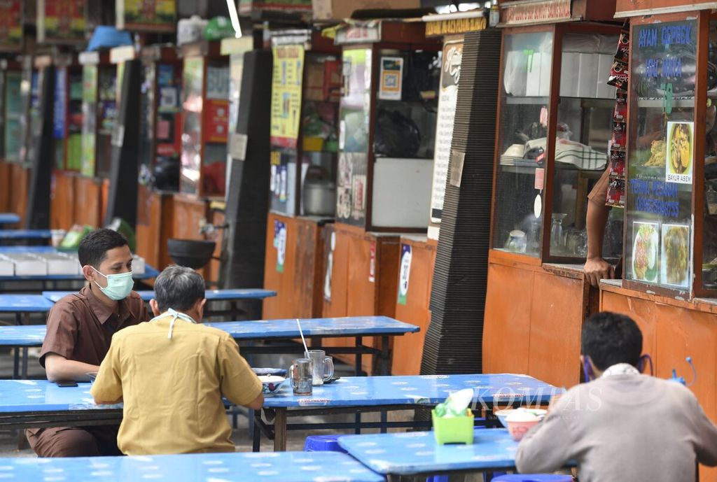 Sejumlah pegawai kantor menikmati makan siang saat jam istirahat di kawasan Kebon Sirih, Jakarta Pusat, Senin (20/4/2020). Aktivitas perkantoran yang berkurang di tengah pandemi Covid-19 turut berimbas pada menurunnya usaha kuliner yang berada di kawasan perkantoran. Saat ini penerapan pembatasan sosial berskala besar (PSBB) di Jakarta telah memasuki hari ke-11.