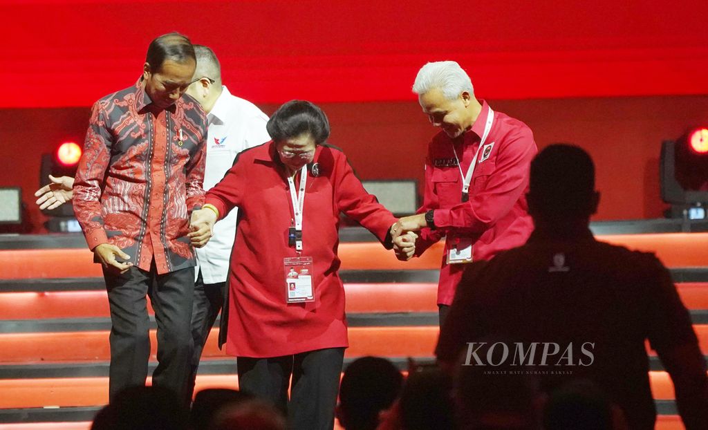 Presiden Joko Widodo (kiri) dan bakal calon presiden yang diusung PDIP Ganjar Pranowo (kanan) bersama-sama memegang tangan Ketua Umum PDIP Megawati Soekarnoputri (tengah) untuk turun panggung pada acara pembukaan Rapat Kerja Nasional (Rakernas) IV PDIP di Jakarta International Expo, Kemayoran, Jakarta, Jumat (29/9/2023).