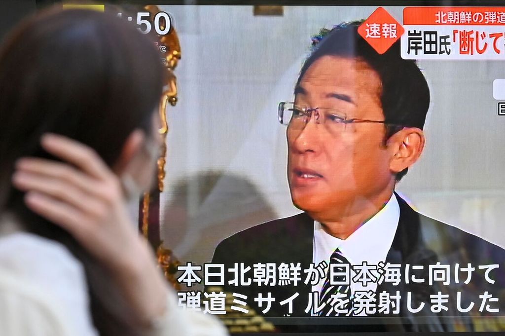 Seorang pejalan kaki menonton siaran berita televisi di Tokyo yang melaporkan tentang peluncuran rudal balistik Korea Utara, sambil menunjukkan gambar pidato Perdana Menteri Jepang Fumio Kishida kepada media selama kunjungannya ke Italia pada 4 Mei 2022. 