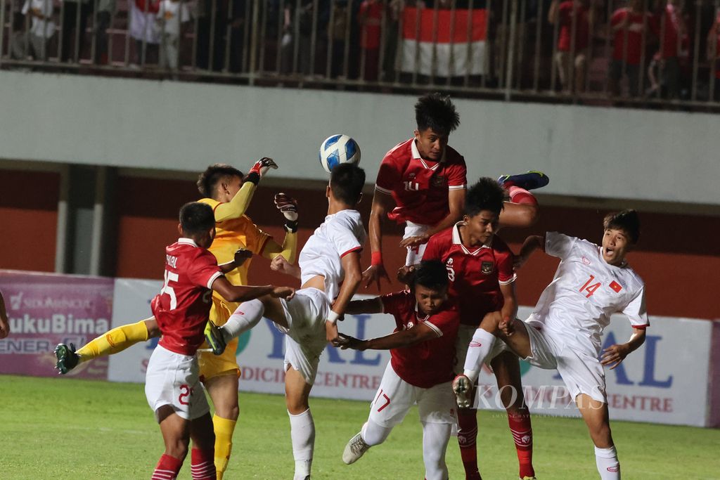 Penjaga gawang tim Vietnam U-16, Pham Dinh Hai (kostum kuning), berusaha membendung serangan tim Indonesia U-16 (kostum merah) dalam laga Piala AFF U-16 di Stadion Maguwoharjo, Sleman, DI Yogyakarta, Sabtu (6/8/2022).