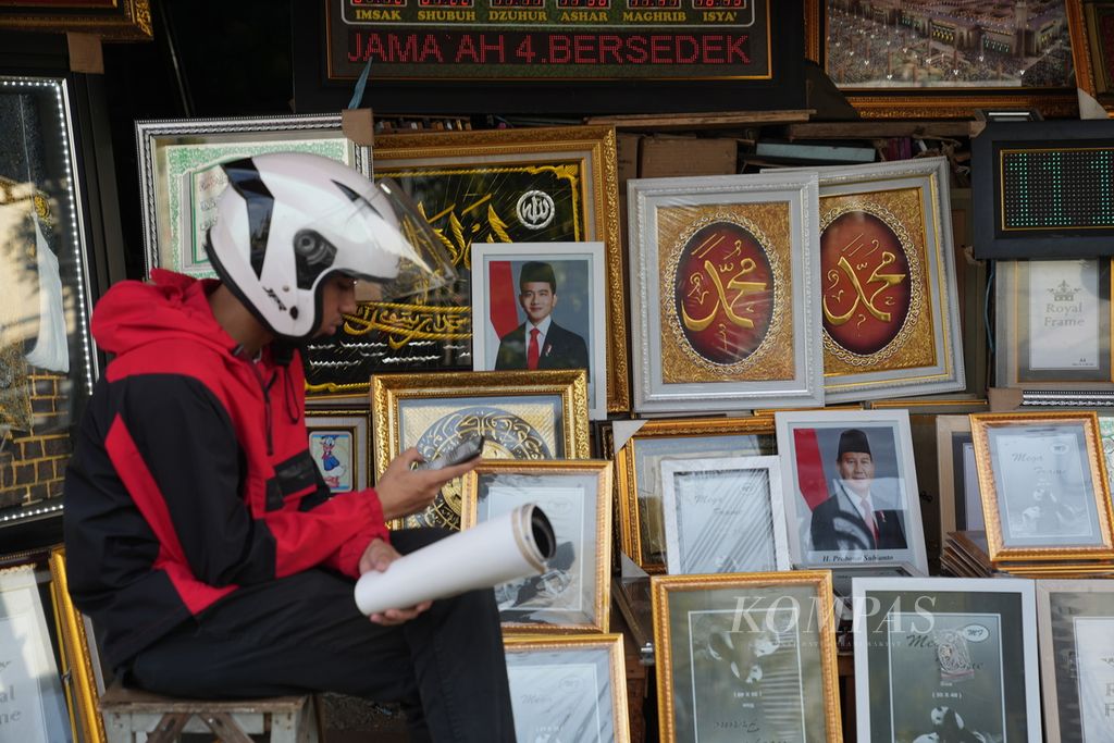 Foto dalam bingkai bergambar presiden dan wakil presiden terpilih, Prabowo Subianto-Gibran Rakabuming Raka, dipajang di sebuah kios di Pasar Jatinegara, Jakarta Timur, Senin (8/4/2024). 