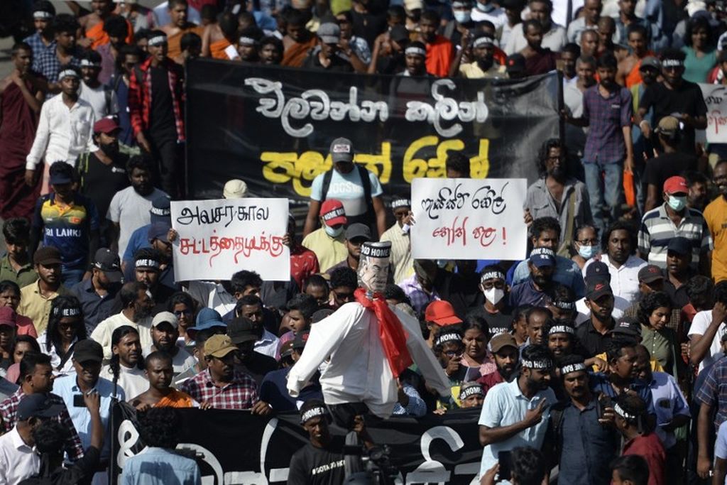 Demonstran membawa orang-orangan berwujud Penjabat Presiden Sri Lanka Ranil Wickremesinghe dan berjalan menuju kantor Sekretariat Presiden dalam protes di Colombo, 19 Juli 2022. 