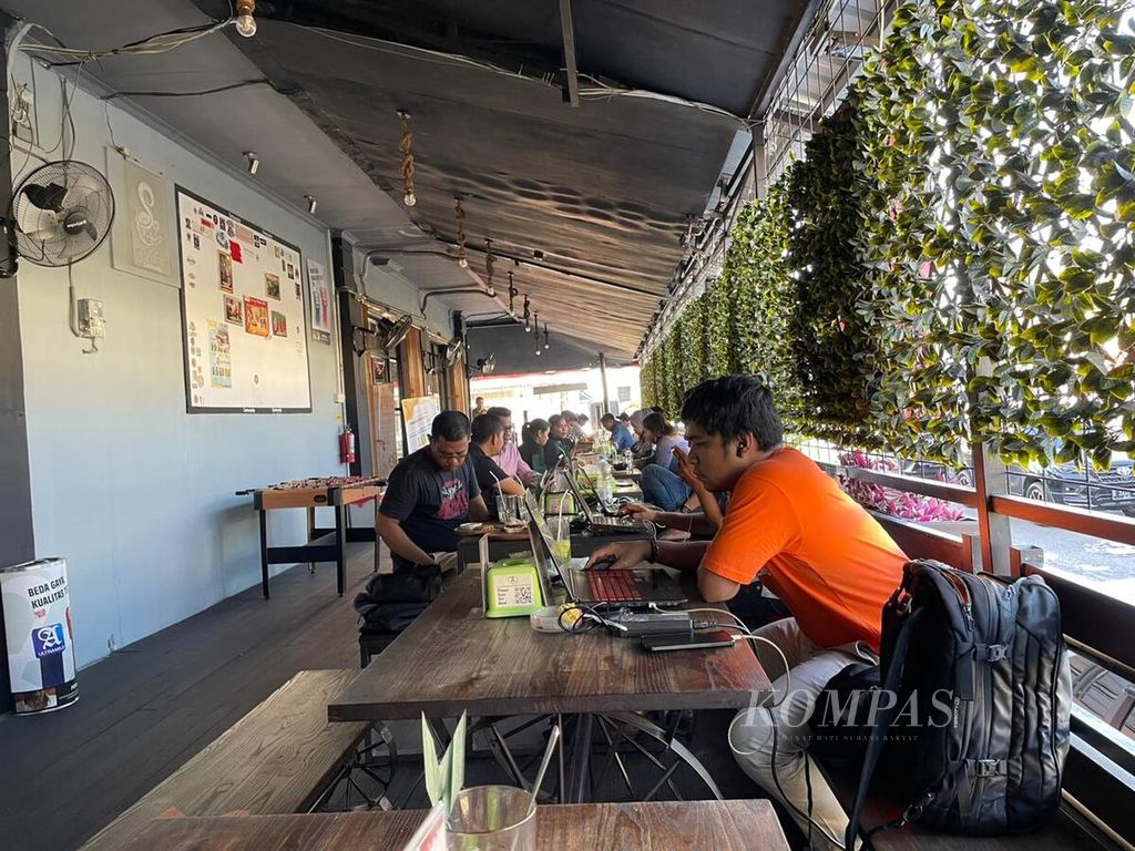 Sejumlah warga bekerja di sebuah kafe yang menggunakan genset di Kota Balikpapan, Kalimantan Timur, Selasa (8/8/2023), menyusul gangguan pada sistem kelistrikan interkoneksi Kalimantan sejak pukul 10.43 Wita.