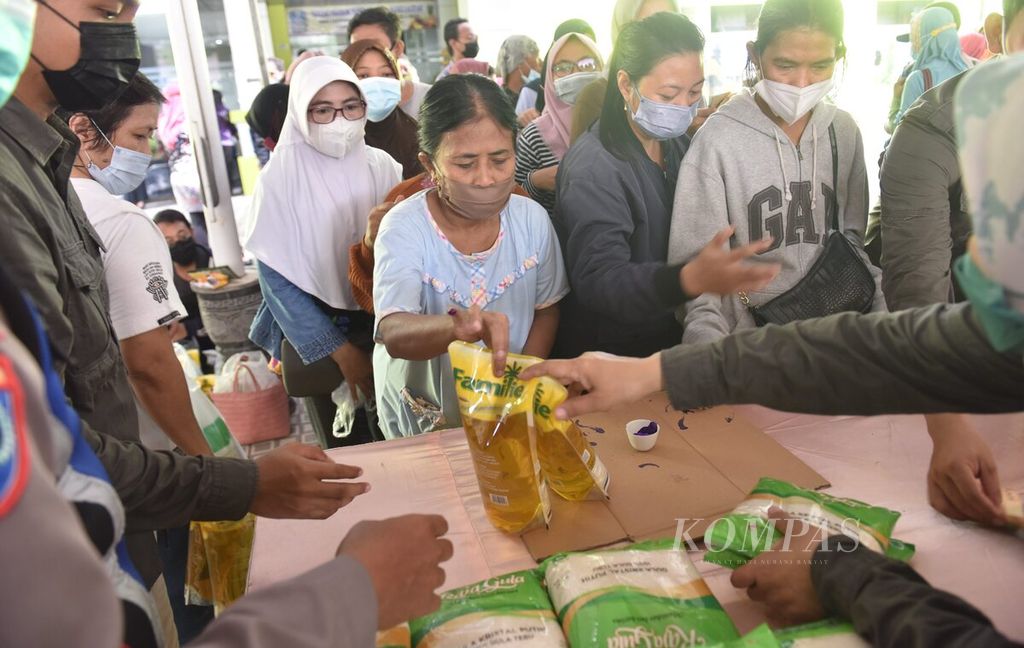 Residents buy cooking oil at the Cheap Quality Food Bazaar at the East Java Office of Agriculture and Food Security, Monday (28/3/2022). Many residents use the bazaar to look for a number of cheap commodities in the midst of rising prices ahead of Ramadan.