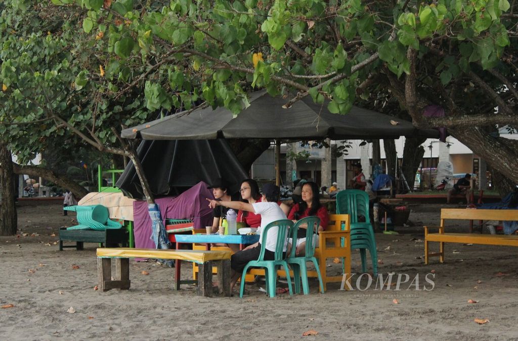 Wisatawan duduk santai di pantai barat Pangandaran, Jawa Barat, Senin (8/8/2022). 