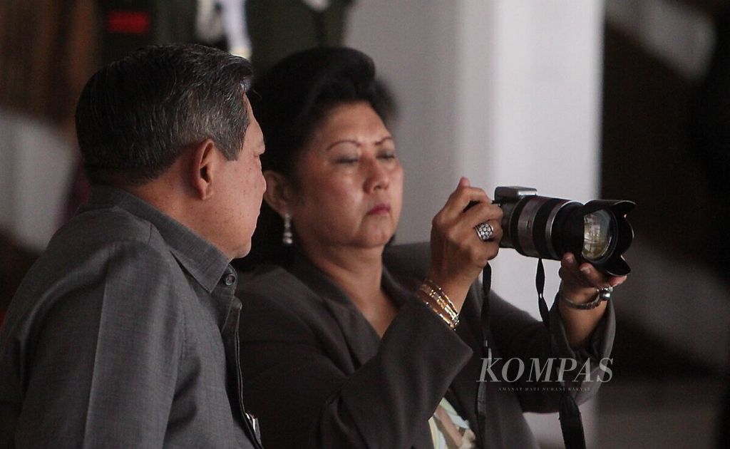 Presiden Susilo Bambang Yudhoyono memperhatikan istrinya, Ny Ani Yudhoyono, yang sedang mengabadikan acara gladi bersih pengibaran bendera yang digelar di halaman depan Istana Merdeka, Jakarta, Senin (15/8/2011). Di rumah, SBY dan mendiang istrinya dipanggil <i>pepo</i> dan<i> memo</i> oleh anak cucu.