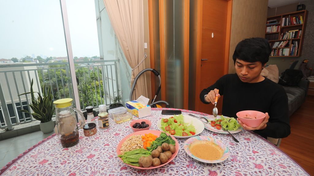 Aktor Muhammad Khan menyantap makan siang berupa salad dan rebusan sayuran organik di balkon apartemennya di kawasan Dharmawangsa, Jakarta Selatan, untuk diunggah di akun media sosial, Jumat (3/9/2021). 