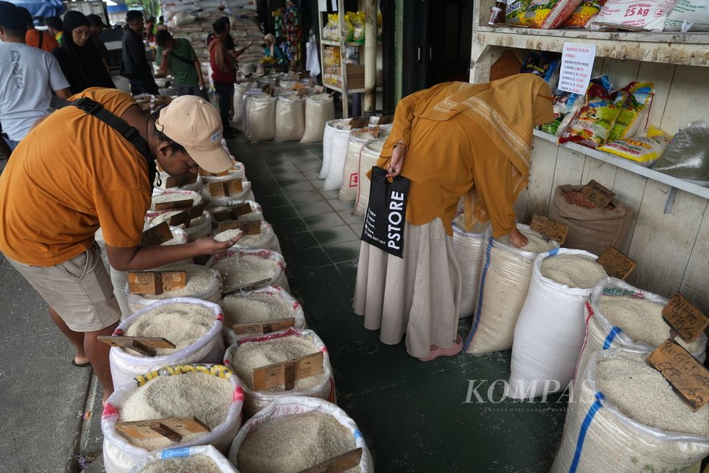 Residents check the quality of rice at the Cipinang Rice Market in East Jakarta on Thursday (25/4/2024). The government has extended the highest retail price for premium rice to IDR 14,900 per kilogram, which has been in effect since March 2024. The reference prices for medium rice, paddy, and corn have also been raised.