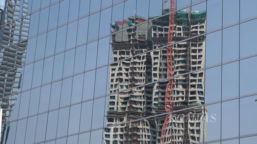 The glass reflections of apartment building construction in the Setiabudi area of South Jakarta on Sunday (23/7/2023). The weakening of the global property market needs to be anticipated by property sector actors in the country by responding to domestic market challenges.