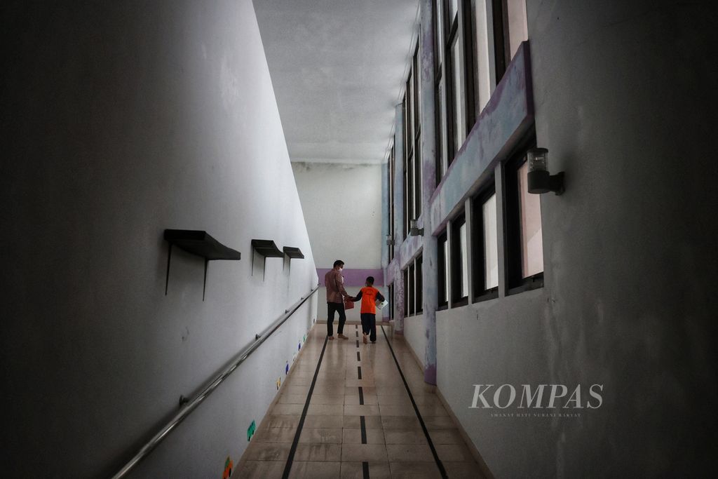 Pengajar mendampingi seorang anak autis yang akan mengikuti sesi kegiatan di Pusat Layanan Autis DI Yogyakarta, Kecamatan Sentolo, Kulon Progo, DI Yogyakarta, Jumat (6/1/2023).