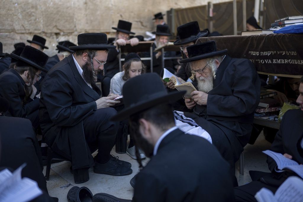 Para penganut Yahudi Ultra-ortodoks berdoa pada Hari Besar Tisha B'Av di Tembok Barat, Jerusalem, Selasa (13/8/2024). 