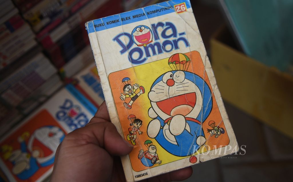 Komik <i>Doraemon </i>di kios Amir di Pasar Loak Gembong, Kota Surabaya, Jawa Timur, Kamis (6/1/2022). Buku komik Jepang yang sempat jaya pada tahun 90-an tersebut dijual Rp 6.000 perkomik.