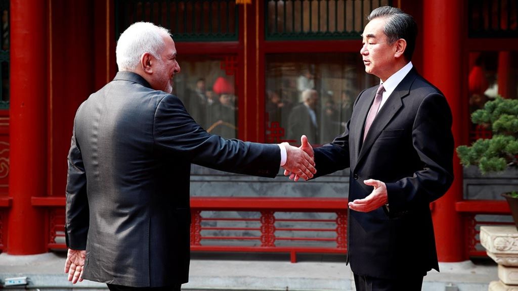 Menteri Luar Negeri Iran Mohammad Javad Zarif (kiri) dan Menlu China, yang juga penasihat negara, Wang Yi berjabat tangan saat bertemu di Wisma Tamu Negara Diaoyutai di Beijing, China, Selasa (19/2/2019).