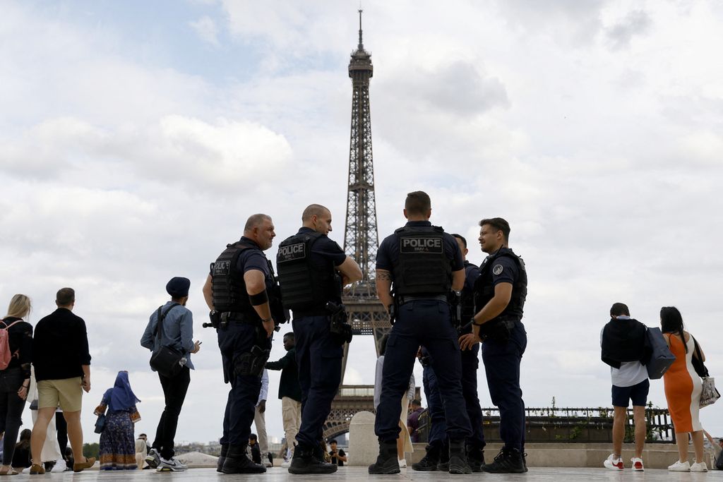 Aparat kepolisian Perancis dari Brigade Aksi Kekerasan (Brav atau Brigade de represi de l'aksi kekerasan) sedang berjaga di Trocadero Plaza, dengan latar belakang Menara Eiffel di Paris, Tabu (5/7/2023). 