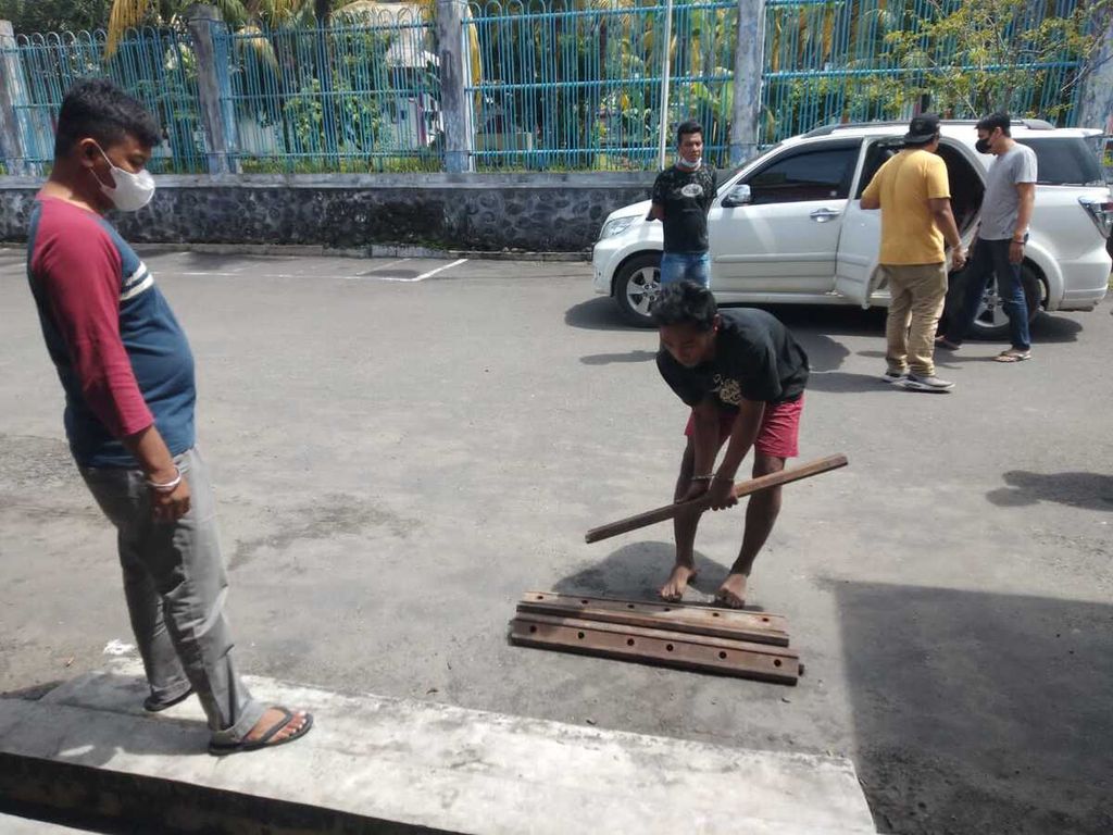 Pelaku (tengah) menunjukkan pelat sambung rel kereta api yang ia curi di Markas Polsek Lubuk Begalung, Padang, Sumatera Barat, Senin (7/2/2022).