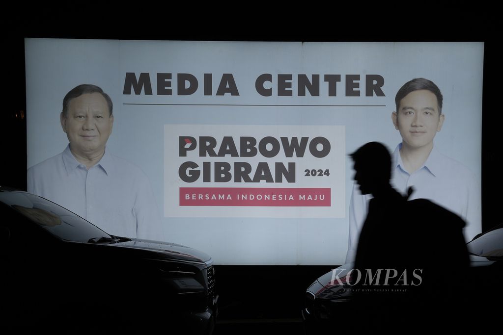 Warga melintasi <i>media center </i>Prabowo-Gibran di Jakarta Selatan, Rabu (20/3/2024). Prabowo-Gibran meraih suara terbanyak di Pemilihan Presiden 2024 berdasarkan hasil rapat pleno penetapan perolehan suara pemilu oleh Komisi Pemilihan Umum. 