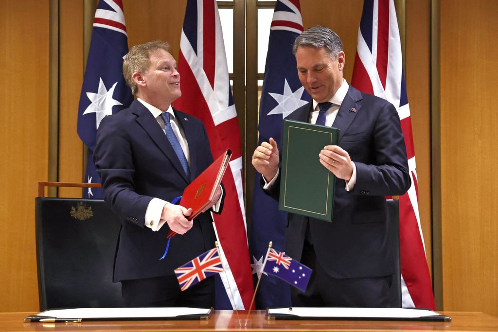 Wakil Perdana Menteri dan Menteri Pertahanan Australia Richard Marles (kanan) dan Menteri Pertahanan Inggris Grant Shapps menandatangani perjanjian pertahanan kedua negara di Gedung Parlemen di Canberra, Australia, 21 Maret 2024.