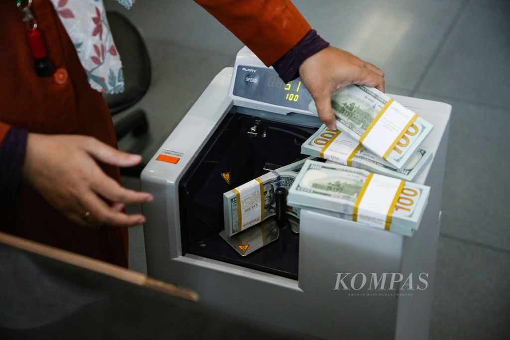 Petugas menghitung uang dollar AS di tempat penukaran valuta asing PT Valuta Inti Prima di Cikini, Jakarta, Senin (20/11/2023).