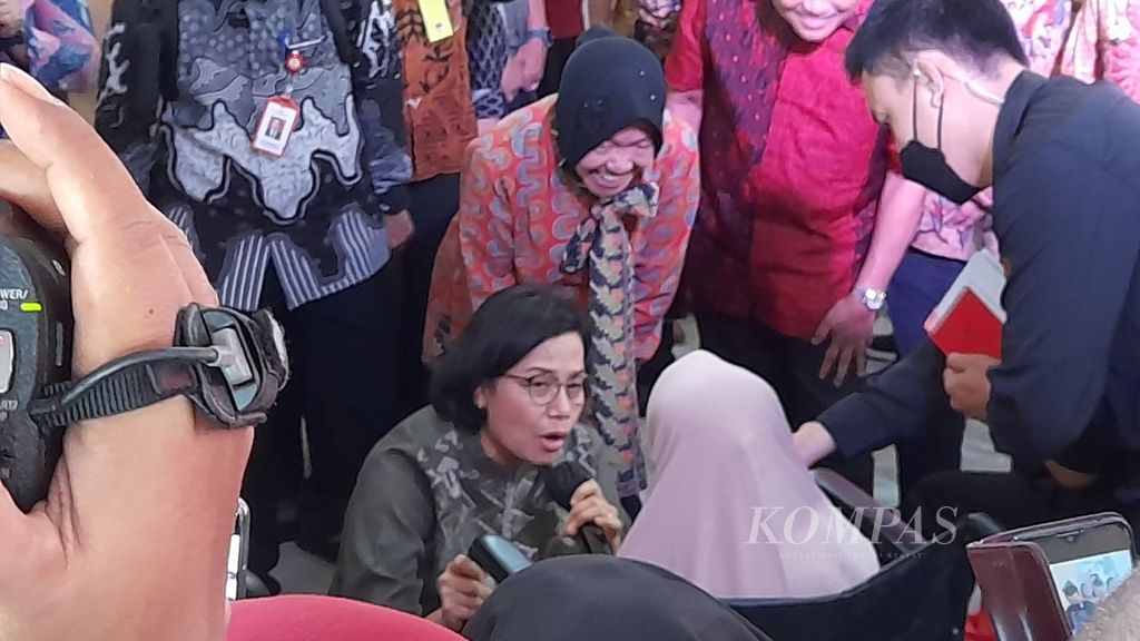 Menteri Keuangan Sri Mulyani Indrawati (berjongkok) dan Menteri Sosial Tri Rismaharini (berdiri, tengah) sedang berdialog dengan penerima manfaat perlindungan sosial di Kabupaten Malang, Jawa Timur, Jumat (20/1/2023).