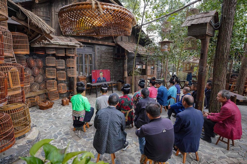 Warga etnis minoritas di Danzhai, Provinsi Guizhou tengah mendengarkan pidato Presiden Xi Jinping dalam pembukaan Kongres Nasional Partai Komunis China, Minggu (16/10/2022).