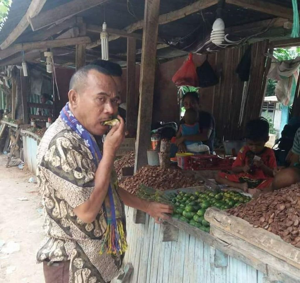 Ken Adolf (38), seorang PNS di Soe, Timor Tengah Selatan, NTT, menghancurkan buah pinang muda dengan giginya untuk dikunyah bersama sirih dan kapur di Pasar Oesao, Kabupaten Kupang.