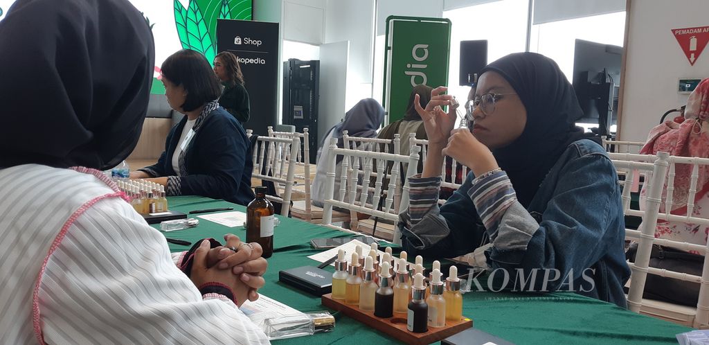 Seorang peserta lokakarya Meracik Parfum Bersama Tokopedia, mengendus aroma salah satu botol berisi wewangian bahan dasar pembuatan parfum, di Jakarta, Rabu (21/2/2024).