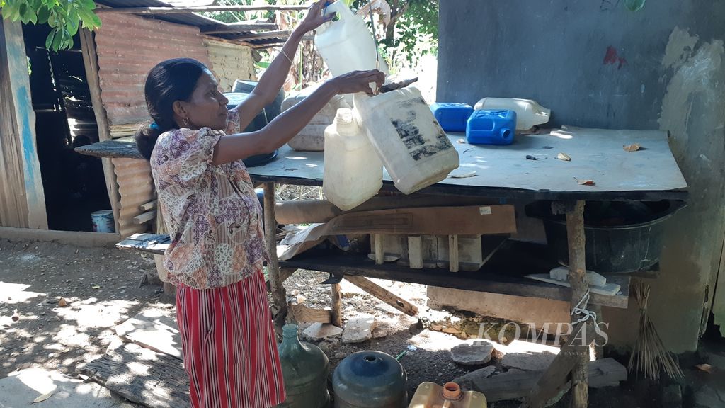 Seorang ibu merapikan jeriken air yang sebelumnya digunakan untuk mengangkut air bersih dari kali di Kampung Oebkin, Kabupaten Timor Tengah Utara, NTT, Kamis (9/6/2022). Sejak hadirnya sumur bor di kampung itu, mereka tidak lagi mengambil air dari kali.