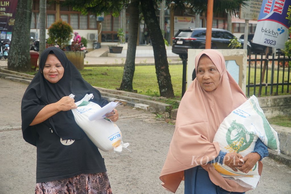 Warga membawa beras bantuan pemerintah yang diambil di kantor Camat Pauh, Kota Padang, Sumatera Barat, Senin (29/1/2024).