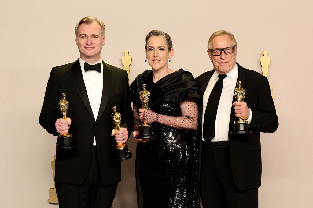 (Dari kiri ke kanan) Christopher Nolan, Emma Thomas, dan Charles Roven, pemenang Best Picture untuk <i>Oppenheimer</i>, berpose di ruang pers dalam gelaran Oscar 2024, Minggu (10/3/2024), di Hollywood, California, Amerika Serikat. 