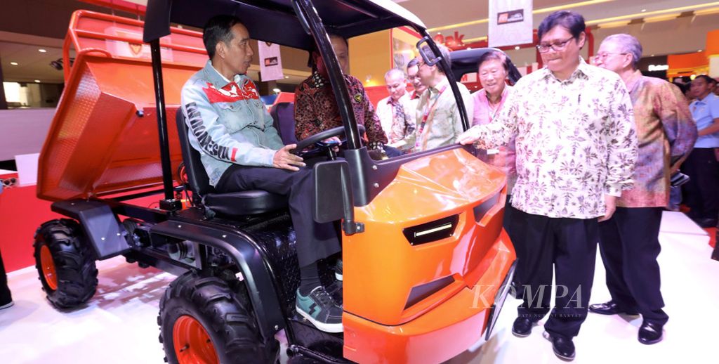 President Joko Widodo, accompanied by Industry Minister Airlangga Hartarto (standing, front), tries out a light truck produced by PT Kiat Mahesa Wintor during the Indonesia International Motor Show 2018 at JI. Expo, Kemayoran, in Jakarta on Thursday (19/4/2018). During the opening of the “Your Infinite Automotive Experience” motor show, the President said Industry 4.0 could drive technological progress in the automotive industry and open up new opportunities.