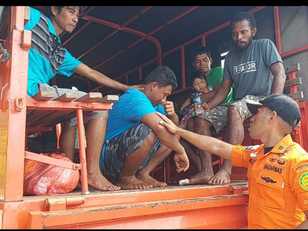 Petugas Tim SAR Timika menenangkan salah satu korban selamat dari peristiwa tenggelamnya Kapal Motor Usaha Baru yang bermuatan kayu 30 kubik dan 18 penumpang di Perairan Timika, Distrik Amar, Kabupaten Mimika, Selasa (5/7/2022).