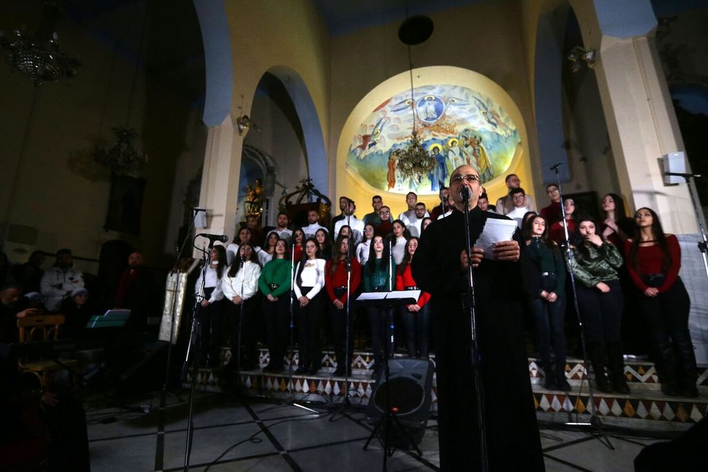 Warga Suriah menyanyikan lagu-lagu Natal di sebuah gereja di Damaskus, Suriah, Sabtu (23/12/2023).