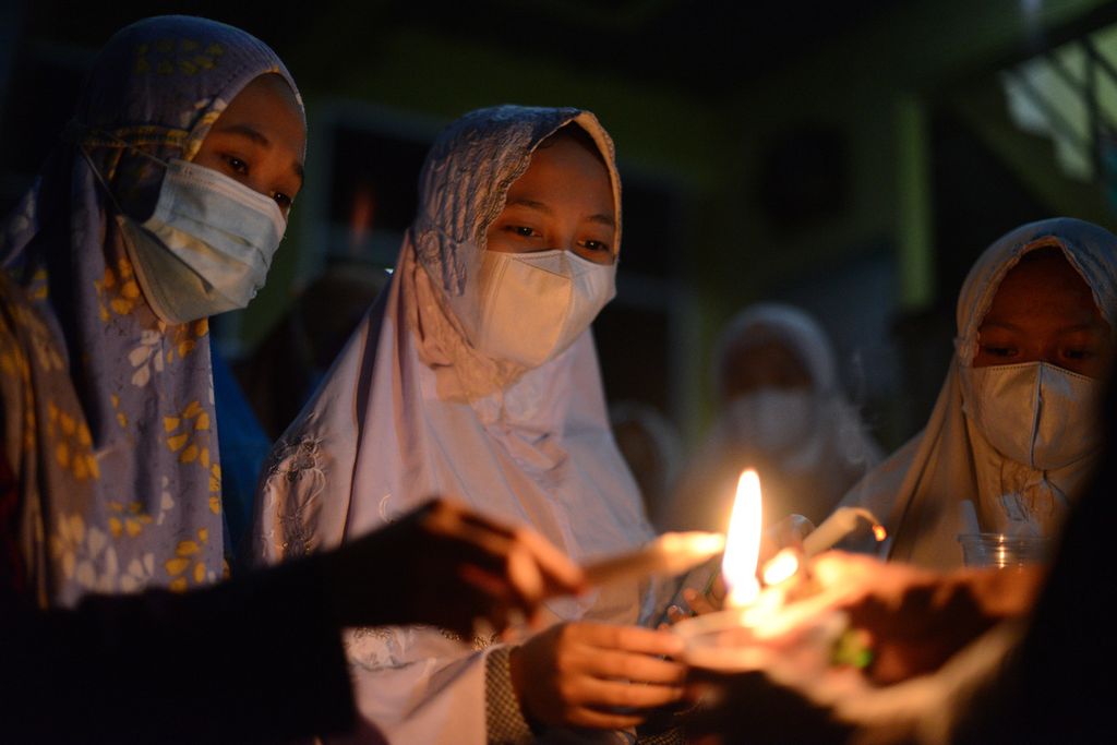 Santri menyalakan lilin sebelum melakukan tadarus untuk memperingati Nuzulul Quran di Pondok Pesantren Nurul Hidayah Al-Mubarokah, Desa Sempu, Andong, Boyolali, Jawa Tengah, Minggu (2/5/2021) malam. 