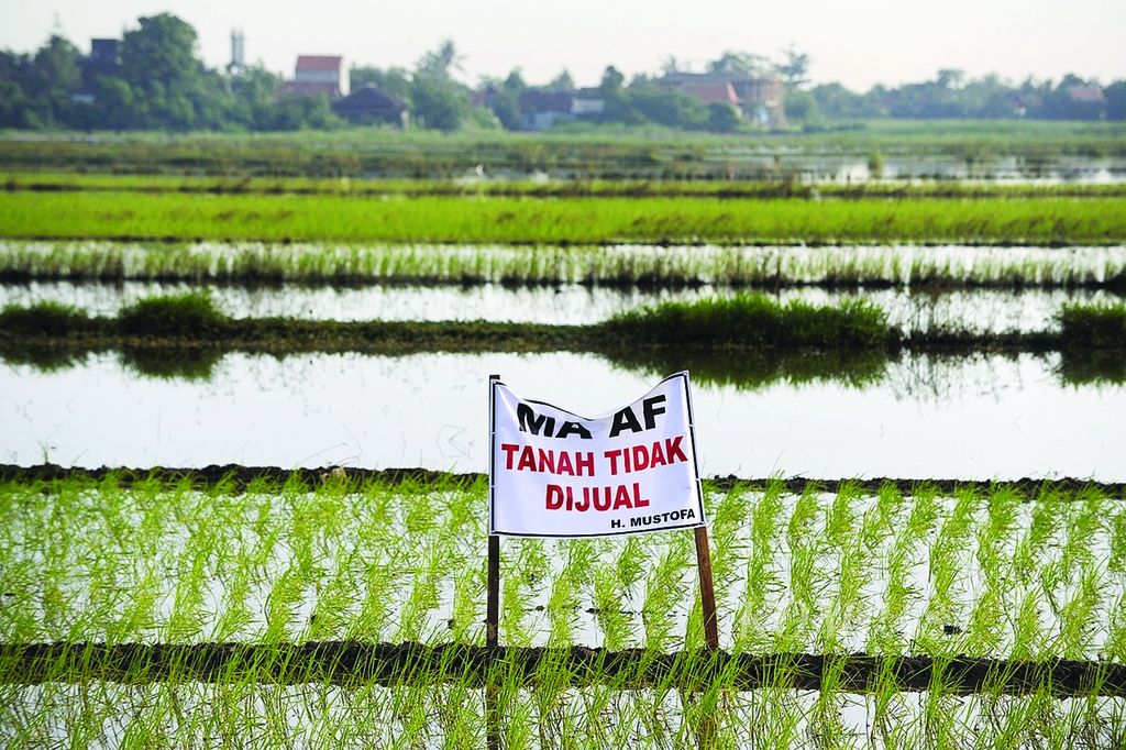 Sebuah poster penolakan menjual lahan terpasang di sawah di Kaliwungu, Kabupaten Kendal, Jawa Tengah, Kamis (31/1).
