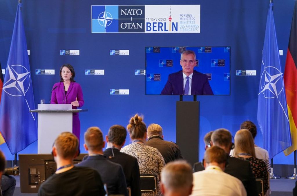 Sekretaris Jenderal NATO Jens Stoltenberg terlihat di layar video saat Menteri Luar Negeri Jerman Annalena Baerbock berpidato pada konferensi pers usai pertemuan informal para Menteri Luar Negeri NATO tentang konflik di Ukraina, Minggu (15/5/2022) di Berlin, Jerman. 