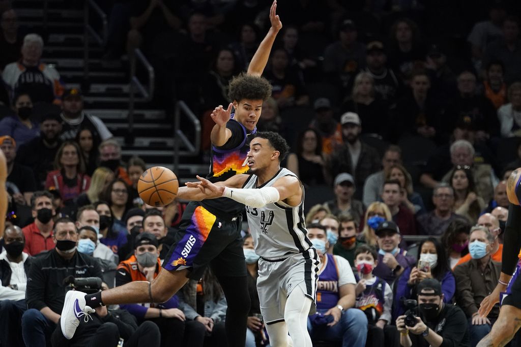 <i>Guard</i> San Antonios Spurs, Tre Jones (kanan), hendak melewati penjagaan <i>forward</i> Phoenix Suns, Cameron Johnson (kiri), pada pertandingan NBA antara Phoenix Suns dan San Antonio Spurs di Phoenix, Minggu (30/1/2022) waktu setempat. Suns mengalahkan Spurs, 115-110.