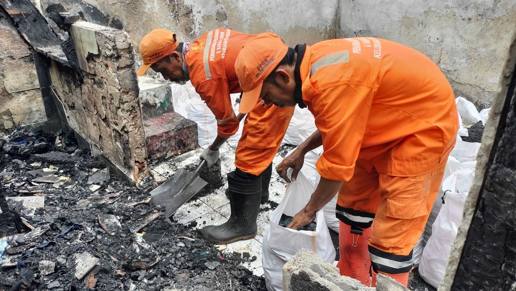 Petugas Penanganan Prasarana dan Sarana Umum (PPSU) Kelurahan Pegangsaan tengah membersihkan di lokasi bangunan yang terbakar dari  puing-puing di Cikini Kramat, Selasa (4/10/2022).