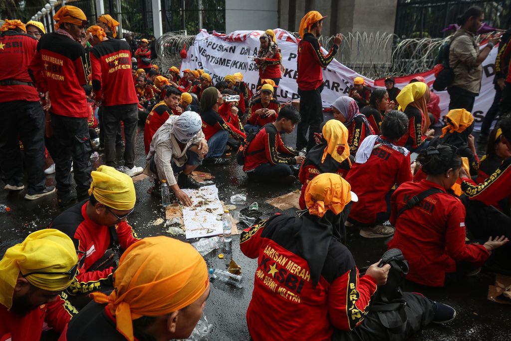 Peserta aksi beristirahat saat mengikuti aksi penolakan Perppu Cipta Kerja di depan Gedung Parlemen, Jakarta, Selasa (28/2/2023). 