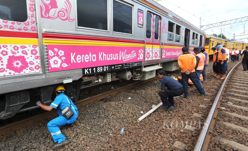 Petugas mengevakuasi rangkaian kereta rel listrik atau KRL 1479 jurusan Bekasi-Manggarai yang anjlok di dekat Stasiun Jatinegara, Jakarta, Rabu (15/3). Akibat peristiwa tersebut, para penumpang terpaksa dialihkan ke kereta lain.