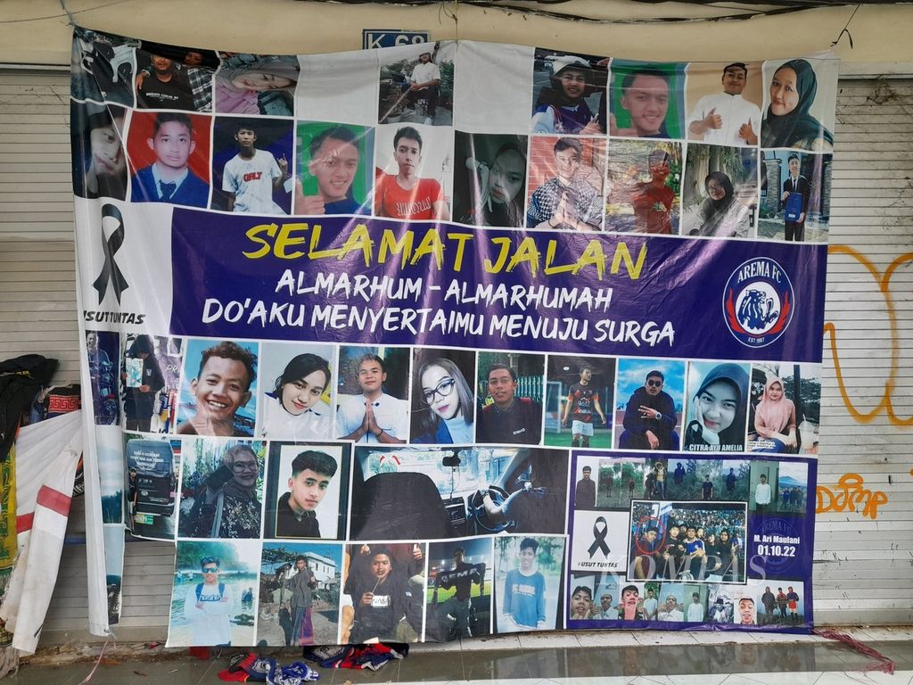 Foto korban tragedi Kanjuruhan dipasang pada spanduk yang ditempatkan dekat pintu 13 Stadion Kanjuruhan, Kabupaten Malang, Jawa Timur, Minggu (2/4/2023). Enam bulan setelah tragedi itu terjadi, proses hukum baru menjerat lima orang terdakwa. Dua orang di antaranya, yang merupakan polisi, divonis bebas. 