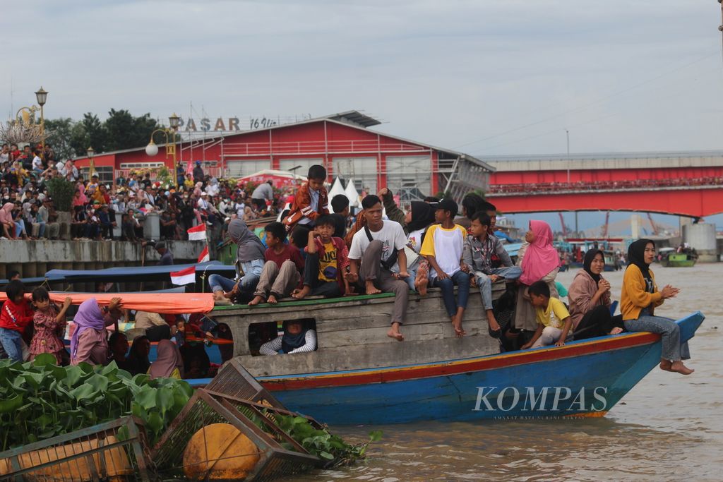 Ratusan warga memadati tepian Sungai Musi, Palembang, Sumatera Selatan, Minggu (21/8/2022). Mereka sedang menunggu final perahu bidar yang merupakan perlombaan yang kerap dilaksanakan pada hari kemerdekaan.