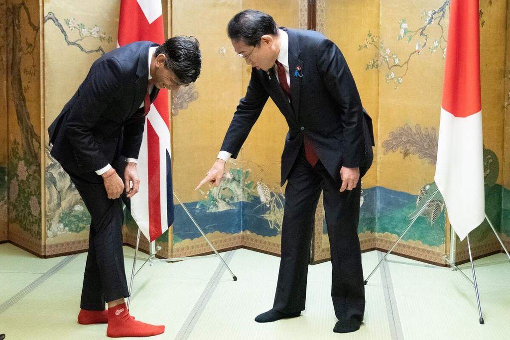 Perdana Menteri Inggris Rishi Sunak memperlihatkan kaos kaki yang dikenakannya kepada Perdana Menteri Jepang Fumio Kishida saat mereka bertemu di Hiroshima, Kamis (18/5/2023). Pada kedua kaos kaki berwarna merah itu terdapat nama tim baseball favorit PM Kishida, Hiroshima Toyo Carp.