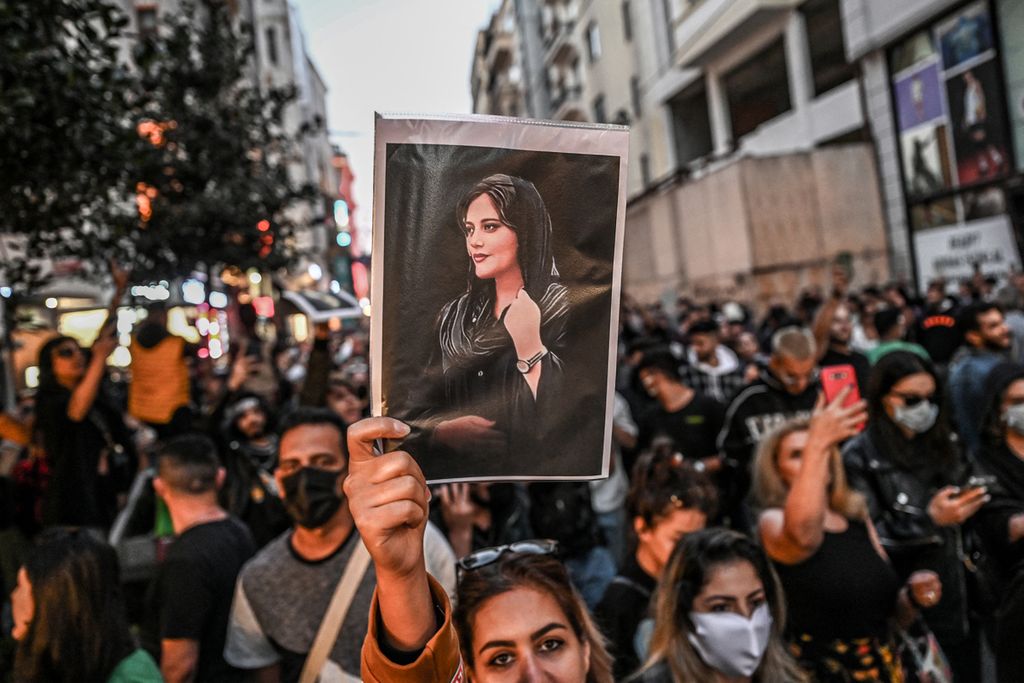 Pengunjuk-rasa membawa poster bergambar Mahsa Amini dalam demonstrasi mendukung Amini (22) di Jalan Istiklal di Istanbul, 20 September 2022. Amini meninggal di tahanan kepolisian moral di Teheran setelah koma selama tiga hari. Ia ditahan polisi karena dianggap tidak mengenakan jilbab sesuai aturan. 