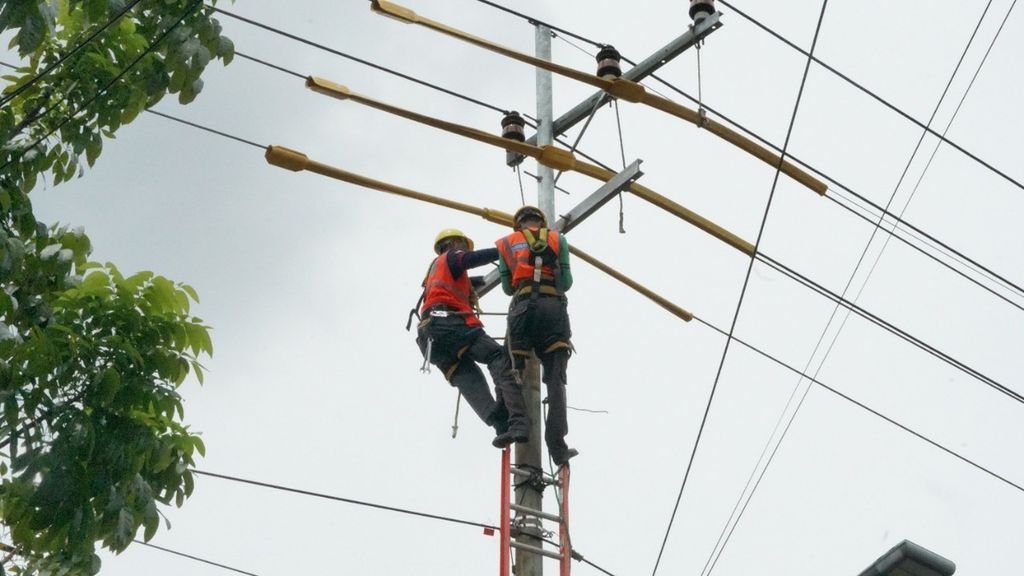 Ilustrasi petugas PLN Distribusi Jatim memperbaiki jaringan listrik untuk menjaga keandalan pasokan pada musim hujan dan saat cuaca ekstrem.