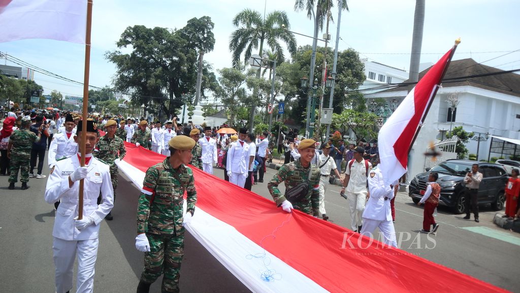 Petugas membawa bendera Merah Putih sepanjang 500 meter dalam Kirab Merah Putih di depan Balai Kota Cirebon, Jawa Barat, Senin (6/3/2023). Kegiatan yang diikuti berbagai elemen masyarakat itu untuk membangkitkan rasa cinta Tanah Air.