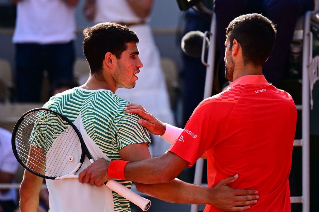 Petenis Serbia, Novak Djokovic (kanan), berupaya menghibur lawannya, Carlos Alcaraz, seusai berakhirnya laga babak semifinal tunggal putra Perancis Terbuka 2023 di Stadion Roland Garros, Paris, Perancis, Jumat (9/6/2023) waktu setempat. Djokovic menang, 6-3, 5-7, 6-1, 6-1.