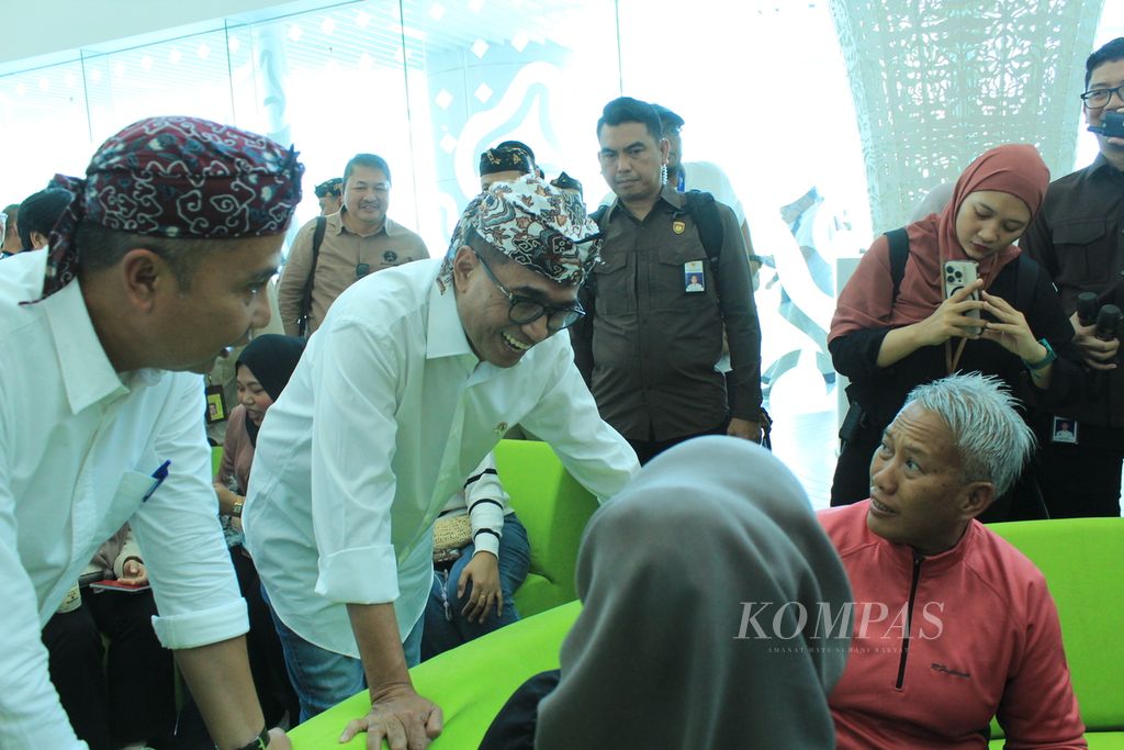Menteri Perhubungan Budi Karya Sumadi (mengenakan kacamata) berbincang dengan penumpang asal Malaysia di Terminal Bandara Internasional Jawa Barat Kertajati di Kabupaten Majalengka, Jawa Barat. 