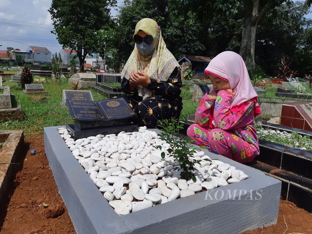 Soliha, warga Depok, Jawa Barat, mengunjungi makam anaknya, Azqira (3,8), Selasa (25/10/2022). Soliha ditemani Nai (3), keponakan sekaligus teman bermain Azqira. Sejak meninggal karena gangguan ginjal akut pada Minggu (16/10/2022), setiap pagi Soliha selalu mengunjungi makam anaknya.