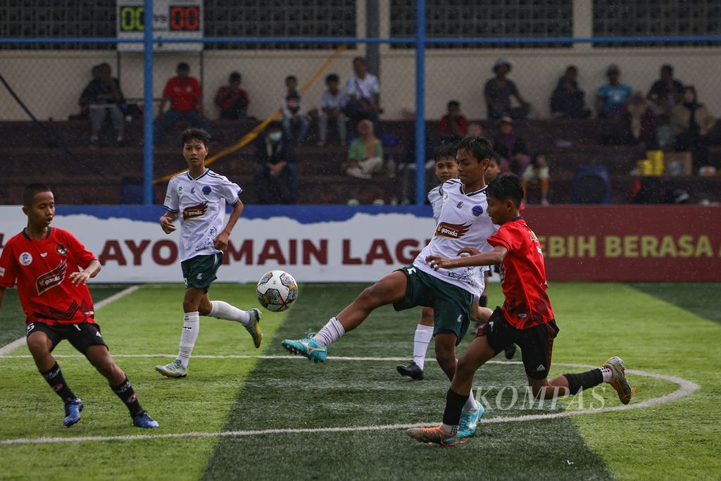 Kapten BM IFA, Ahmad Raditya Akmal (kedua dari kanan), berebut bola dengan pemain Putra Agung, Faris Abqariyoris (kanan), dalam laga babak utama Liga Kompas Kacang Garuda U-14 di Dewantara Sport Center, Tangerang Selatan, Banten, Minggu (31/12/2023).