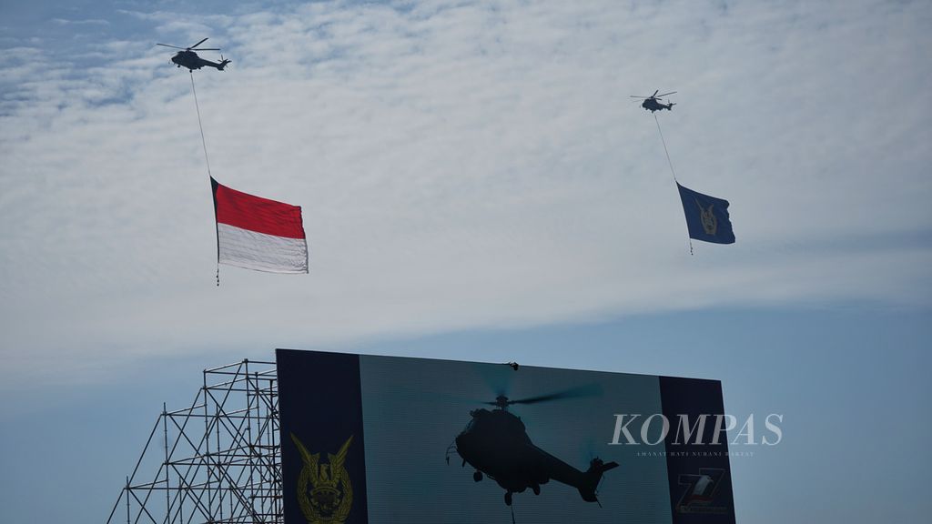  Helikopter Super Puma saat membawa bendera raksasa saat gladi bersih untuk acara Puncak Peringatan HUT Ke-77 TNI Angkatan Udara di Pangkalan Udara Halim Perdanakusuma, Jakarta, Kamis (6/3/2023).